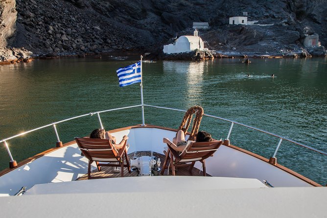 Santorini: Motor Yacht Sunset Cruise with 5-Course Dinner - The caldera drive-by: red and white beaches, Indian Head, and Akrotiri Lighthouse
